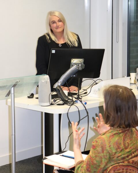 Selina Sasse, female CEO, stands at the front of the lecture on the state of yoga in UK prisons